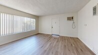 Located at 217 W. Tujunga Ave. in Burbank, CA, this single-floor, 2-bedroom, 2-bathroom unit offers a practical and well-organized layout. The living room greets you with light wood-look flooring, a ceiling fan, a large window with vertical blinds that invites natural light, and a wall-mounted A/C unit for year-round comfort. Textured ceilings are consistent throughout the common areas.

The combined dining and kitchen area features gray cabinetry, tile countertops, a gas cooktop, a tiled backsplash, a range hood, and a window with vertical blinds. A pantry provides additional storage to complement the kitchen's cabinetry.

Both bedrooms are carpeted and feature textured ceilings. The primary bedroom is a comfortable size and includes a sliding double-door closet. The second bedroom offers a high horizontal window that allows in natural light. A hallway connects the rooms and includes four closets, offering generous storage space throughout.

The two bathrooms differ in style: one features wood-look flooring, a white vanity with a medicine cabinet mirror, and a natural-light window, while the second includes a full bathtub/shower combination with white tile surround and overhead cabinetry. Both bathrooms maintain a clean, neutral aesthetic.