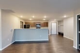 Located at 3500 S Grand Slam Ave in Sioux Falls, SD, this single-floor residence offers a thoughtfully designed 2-bedroom, 2-bathroom layout with a comfortable and functional floor plan. The open-concept living and kitchen area serves as the heart of the home, featuring dark hardwood-style flooring, recessed lighting, and a large kitchen island with light stone countertops. The kitchen is equipped with dark wood cabinetry, black appliances including a refrigerator, range, microwave, and dishwasher. A built-in drop zone with shelving near the entry adds convenient everyday storage. The living room is bright and spacious, with sliding glass doors opening to a private balcony. Both bedrooms are carpeted and offer generous proportions, with the primary bedroom being particularly spacious and featuring its own dedicated closet. The primary bathroom includes wood-toned cabinetry, a light stone vanity top, wood-look tile flooring, and a walk-in closet. The second bathroom mirrors this aesthetic and includes a full tub-shower combo. A utility room houses mechanical systems on-site. Neutral tones throughout create a clean, move-in ready atmosphere.