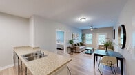 Located at 1446 Russell St in Rock Hill, SC, this well-appointed 2-bedroom, 2-bathroom residence offers a practical and comfortable single-floor layout designed for everyday living. Light wood-tone flooring flows throughout, creating a cohesive and airy atmosphere across all rooms.

The combined kitchen and living area serves as the heart of the home. The living room features a ceiling fan, neutral walls, and a window that invites natural light. The kitchen is equipped with light wood cabinetry, stainless steel appliances including a refrigerator, microwave, and range, granite-style countertops, and a peninsula with seating — ideal for casual dining or meal prep.

The primary bedroom is a generously sized retreat featuring a ceiling fan, soft neutral tones, and an arched-door closet. The second bedroom also includes a ceiling fan and a large window overlooking greenery, providing pleasant natural light and outdoor views. A dedicated closet adds practical storage to the layout.

Both bathrooms are cleanly finished with wood-tone cabinetry, granite-style countertops, mirrored vanities, and tile-surround tub-shower combinations. The overall design is clean and consistent, with neutral tones and modern fixtures unifying the space throughout.