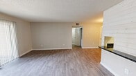 Located at 1811 W Lakeview Dr in Johnson City, TN, this one-bedroom, one-bathroom unit offers a well-designed single-floor layout that maximizes every square foot of its cozy footprint. The open-concept living and kitchen area serves as the heart of the home, featuring durable hardwood-style flooring throughout. A standout fireplace with a clean white mantel anchors the living room, complemented by a sliding glass door that opens to a private patio and allows natural light to fill the space. The kitchen is efficiently laid out with white cabinetry, dark speckled countertops, a double-basin stainless steel sink, and white appliances including a refrigerator and range. A pass-through counter connects the kitchen to the living area, enhancing the open feel. A chandelier adds a touch of elegance to the transition between the kitchen and hallway. The bedroom offers plush carpeting, a ceiling fan with light fixture, and a window providing natural light. A dedicated closet provides convenient storage. The bathroom includes a full-size tub and shower combination. Textured ceilings and neutral warm-toned walls are consistent throughout, creating a cohesive and inviting ambiance.