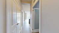 Located at 15 Maple Ave in Barrie, Ontario, this well-appointed two-bedroom, one-bathroom unit offers a thoughtfully designed layout with modern finishes throughout. The open-concept kitchen and living area serves as the heart of the home, featuring rich dark cabinetry, a mosaic tile backsplash, stainless steel appliances including a range and built-in microwave, and a peninsula with a white quartz countertop and pendant lighting — perfect for casual dining or entertaining. Light hardwood flooring extends through the living area, which opens onto a private balcony through floor-to-ceiling sliding glass doors, offering expansive city views and generous natural light. The primary bedroom is a comfortable retreat with plush carpeting, while the second bedroom also features carpet and a large window with city-facing views. A dedicated closet provides additional storage. The four-piece bathroom is finished with large-format white wall tiles, a marble-accented border, and a combined tub and glass-enclosed shower. A separate laundry room with stacked washer and dryer and built-in shelving adds everyday convenience. Neutral grey tones and clean white trim create a cohesive, contemporary aesthetic throughout the entire unit.