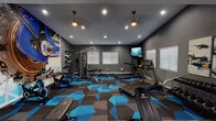 This contemporary fitness center is designed to inspire an active lifestyle, combining stylish aesthetics with a comprehensive range of workout equipment. The space is unified by a bold geometric carpet in deep blue, gray, and charcoal tones, lending a dynamic, energetic feel throughout. Dark gray walls and recessed lighting, complemented by two pendant fixtures, create a focused and motivating atmosphere.

The cardio zone features multiple treadmills and a wall-mounted flat-screen television, allowing users to stay entertained during their workouts. Natural light filters in through several windows fitted with white shutters, brightening the space alongside the recessed ceiling lights.

A striking large-format wall mural depicting a close-up of a bicycle chain and gear serves as a dramatic focal point near the cycling stations, where spin bikes are lined up for group or individual use. A full-length mirror along one wall visually expands the space and is practical for form-checking during exercise.

The free weights area is well-appointed with a complete dumbbell rack, kettlebells, medicine balls, and adjustable benches, while a multi-function cable machine supports a wide variety of strength training exercises. A section of hardwood-style flooring delineates the free weights zone, offering a comfortable surface for stretching and floor work. Double glass doors open to an outdoor area, adding a welcoming sense of openness to this thoroughly equipped fitness facility.