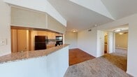 This 2-bedroom, 1-bathroom unit is thoughtfully laid out across a single floor, making efficient use of its space. The combined kitchen and living area serves as the heart of the home, featuring warm hardwood-style flooring, light wood cabinetry, granite-look countertops, a tile backsplash, and black appliances including a refrigerator and range. A peninsula counter provides additional workspace and a natural separation between the kitchen and living area.

The two bedrooms are carpeted for comfort and each features a ceiling fan with light fixture. The primary bedroom stands out with vaulted ceilings and a large window that brings in natural light and greenery views. The second bedroom also offers a window with outdoor views and includes a closet. An additional dedicated closet space provides extra storage for the unit.

The bathroom is clean and straightforward, featuring a tub-shower combination with white tile surround. A hallway connects the main living spaces to the bedrooms and bathroom, creating a logical and practical flow throughout the unit. Neutral tones and consistent finishes throughout contribute to a cohesive and move-in ready atmosphere.
