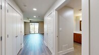 This studio in Austin, TX offers a smart, efficient layout thoughtfully designed to maximize every square foot. The open-concept living area is anchored by smooth wood-style plank flooring that flows throughout the space, complemented by neutral warm-toned walls and recessed lighting that create a clean, inviting atmosphere. A ceiling fan adds both style and function to the main living area, while large sliding glass doors flood the room with natural light and provide direct access to an outdoor balcony with lush tree views.

The kitchen is well-appointed with warm wood cabinetry, granite countertops, a tiled subway-style backsplash in cool blue-green tones, a stainless steel sink, black appliances including a dishwasher and range, and ample upper and lower cabinet storage. The kitchen opens conveniently toward the main living area, allowing for easy interaction between the two spaces.

The bathroom features white subway tile surrounding a full soaking tub and shower combo with a curved glass panel, tile flooring, and clean, contemporary fixtures throughout. A separate closet with a paneled door provides dedicated storage. The overall design balances practicality with modern aesthetic appeal, making this Austin studio a comfortable and functional living space.