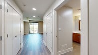 This studio in Austin, TX offers a smart, efficient layout thoughtfully designed to maximize every square foot. The open-concept living area is anchored by smooth wood-style plank flooring that flows throughout the space, complemented by neutral warm-toned walls and recessed lighting that create a clean, inviting atmosphere. A ceiling fan adds both style and function to the main living area, while large sliding glass doors flood the room with natural light and provide direct access to an outdoor balcony with lush tree views.

The kitchen is well-appointed with warm wood cabinetry, granite countertops, a tiled subway-style backsplash in cool blue-green tones, a stainless steel sink, black appliances including a dishwasher and range, and ample upper and lower cabinet storage. The kitchen opens conveniently toward the main living area, allowing for easy interaction between the two spaces.

The bathroom features white subway tile surrounding a full soaking tub and shower combo with a curved glass panel, tile flooring, and clean, contemporary fixtures throughout. A separate closet with a paneled door provides dedicated storage. The overall design balances practicality with modern aesthetic appeal, making this Austin studio a comfortable and functional living space.