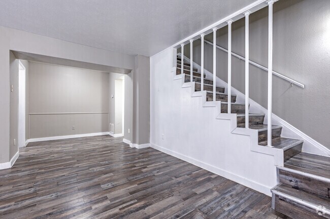 Amplia sala de estar con escalera abierta y suelo estilo madera. - Vista Montana
