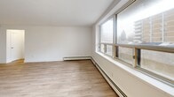 Located at 77 Parkwoods Village Dr in Toronto, this well-appointed one-bedroom, one-bathroom unit offers a thoughtfully designed layout across a single floor. The open-concept kitchen and living area serves as the heart of the home, featuring a galley-style kitchen outfitted with stainless steel appliances, white cabinetry with brushed gold hardware, subway tile backsplash, and dark countertops — all set atop clean light-toned tile flooring. The living area transitions seamlessly from the kitchen and is bathed in natural light through expansive, wide-frame windows that look out onto the surrounding neighbourhood greenery, complemented by light wood laminate flooring and baseboard heating throughout. The bedroom is a comfortable, well-proportioned space with the same warm wood flooring, a window with natural light, and a mirrored sliding closet that adds a sense of openness. The bathroom is finished with neutral taupe wall tiles surrounding a full soaker tub and shower combination, with tile flooring and a clean white vanity. A private balcony provides outdoor access, while a functional hallway connects the main living spaces. The unit's bright, neutral palette and modern finishes create a clean and welcoming atmosphere throughout.
