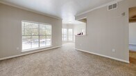 Located at 8100 Huebner Road in San Antonio, TX, this single-floor, 2-bedroom, 2-bathroom residence offers a well-organized layout designed for comfortable everyday living. The open living area is highlighted by large windows with blinds that invite abundant natural light, plush carpet flooring, and elegant crown molding along the ceiling. A textured ceiling adds architectural character, while a built-in pass-through shelf connects the living space to the kitchen area, enhancing the open feel of the home. The primary bedroom is a generously sized retreat featuring a ceiling fan with light fixture, carpet flooring, a dedicated closet, and direct access to a private en-suite bathroom. The primary bathroom is appointed with dark wood cabinetry, a white countertop vanity, a large mirror with overhead lighting, and wood-look tile flooring. The second bedroom is equally well-appointed, offering a ceiling fan, carpet flooring, a window for natural light, and access to an outdoor area via a sliding glass door. The second bathroom mirrors the design of the first, featuring a tub-shower combo, dark wood cabinetry, and matching tile flooring. Both bedrooms include closets, and the layout is completed by a hallway providing efficient access throughout the home.