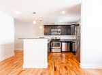 Located at 134 Sussex Ave in Newark, NJ, this single-floor unit offers a thoughtfully designed layout with modern finishes throughout. Warm hardwood flooring runs seamlessly across the living areas and bedrooms, creating a cohesive and inviting atmosphere.

The kitchen is a standout feature, outfitted with dark espresso cabinetry, granite countertops, and a full suite of stainless steel appliances including a range, microwave, dishwasher, and refrigerator. A central island with pendant lighting adds both functionality and style, making the kitchen ideal for cooking and casual dining.

The bedrooms are generously sized with clean white walls, hardwood floors, and windows that invite natural light and offer views of the surrounding neighborhood. Each room is equipped with a wall-mounted PTAC unit, providing individual climate control year-round.

The bathroom is finished with elegant marble-style wall tiles, a full soaking tub with an overhead shower, and crisp white fixtures, creating a clean and contemporary feel.

The overall layout, as reflected in the floor plan, is efficient and well-organized, with clear separation between living, sleeping, and utility areas. The unit's neutral palette and quality finishes make it a versatile and attractive space in the heart of Newark.