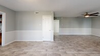 Located on Cedar Springs Road in Dallas, TX, this single-story 2-bedroom, 2-bathroom home offers a practical and comfortable layout. Light-toned wood-look tile flooring flows consistently throughout the main living areas and bedrooms, creating a cohesive and easy-to-maintain interior. The open living room is well-lit by natural light through blinds-fitted windows and features a ceiling fan overhead, while a half-wall divider subtly defines the transition toward the rest of the home. The kitchen is equipped with rich dark wood cabinetry, a metallic diamond-pattern tile backsplash, granite-style countertops, a stainless steel dishwasher, and a stainless steel range with microwave above — alongside a separate entry door with adjacent window that allows additional natural light. Both bedrooms are generously proportioned, each featuring ceiling fans and neutral gray walls. The spacious primary bedroom offers ample room for furnishings. The two bathrooms are tiled with bold diagonal-pattern stonework; one includes a tub-shower combo with sliding glass doors, while the other features a walk-in shower enclosure with sliding glass panels and a built-in niche. A connecting hallway with stone-look tile links the main areas of the home efficiently.