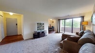 Located at 16 Brandywine in Amherst, Massachusetts, this single-floor unit at Brandywine Apartments offers a well-organized layout designed for comfortable everyday living. The carpeted living room serves as the central gathering space, featuring a large sliding glass door that opens onto a private balcony with lush, tree-lined views, filling the room with natural light. The open connection between the living room and dining area creates a seamless flow for entertaining and daily use. The dining area features rich hardwood-style flooring and a window that further enhances the sense of openness. The galley-style kitchen is efficiently designed with wood-tone cabinetry, white appliances including a gas range, ample counter space, and direct access to the dining area. Two carpeted bedrooms each offer generous closet space with bi-fold doors, providing practical storage solutions. The full bathroom is equipped with a tub-shower combination and a wood-accented vanity with a built-in sink. Throughout the unit, neutral wall tones and consistent finishes contribute to a clean, cohesive aesthetic. The balcony access and surrounding greenery make this a notably serene residential setting within close proximity to the University of Massachusetts Amherst campus.