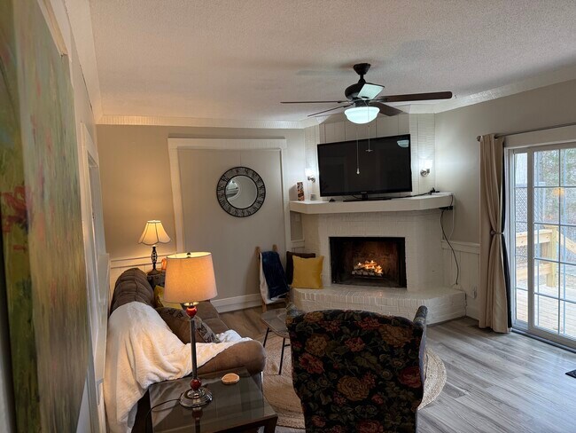 Large bright scenic views from the living room of private deck, yard, and pond. - 718 Dogwood Hill Ln