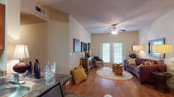Located at 7461 Kitty Hawk Rd in Converse, Texas, this single-story residence offers a well-designed layout with warm, consistent wood-style flooring flowing throughout the main living areas. The open-concept kitchen is outfitted with rich wood cabinetry, granite-style countertops, black appliances including a range, microwave, and refrigerator, and a breakfast bar that connects seamlessly to the dining and living spaces. A central hallway links the main areas to the private quarters, providing a clear and functional flow.

The living room is a standout space, featuring vaulted ceilings, a ceiling fan, and a set of French doors that fill the room with natural light while offering access to the outdoors. The bedroom is a comfortable retreat with carpeted flooring, vaulted ceilings, a ceiling fan, and direct access to a full bathroom. The bathroom includes granite-topped vanity cabinetry and a shower-tub combination, while an adjoining walk-in closet with built-in shelving provides generous storage. A second vanity area with granite countertops and mirrored walls is also accessible from the hallway. Throughout the residence, neutral wall tones and consistent finishes create a cohesive and inviting atmosphere.