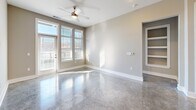 Located at 146 Roberts St in Asheville, NC, this contemporary 3-bedroom, 2-bathroom residence offers a sleek, modern aesthetic throughout its well-appointed single floor. Polished concrete floors run seamlessly through every room, reflecting natural light and lending an industrial-chic character to the space.

The open-concept kitchen is a standout, featuring two-tone cabinetry — natural wood upper cabinets paired with deep navy lower cabinets — granite countertops, a white subway tile backsplash, and a full suite of stainless steel appliances including a side-by-side refrigerator, range, microwave, and dishwasher. Pendant lighting over the kitchen peninsula adds a refined touch, while sight lines extend directly into the living area.

The living room is bright and airy, with large windows and a glass door opening onto a private balcony, flooding the space with natural light. A ceiling fan and built-in shelving add both comfort and functionality.

Each of the three bedrooms is well-lit with multiple windows offering outdoor views, and includes a ceiling fan and closet access. The four closets throughout — including walk-in configurations with wire shelving systems — provide ample storage.

Both bathrooms are finished with granite-topped dark vanities, large mirrors, and polished concrete floors. One features a glass-enclosed walk-in shower, while the other includes a soaking tub. A dedicated laundry room completes this refined Asheville residence.