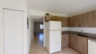 Located at 8328 NW Seventh St in Miami, FL, this two-story home offers a clean, functional layout spread across two levels. Light-toned ceramic tile flooring runs consistently throughout the interior, contributing to a bright and cohesive aesthetic. The main level features an open living area bathed in natural light from a front-facing window dressed with vertical blinds, alongside a front entry door and a staircase leading to the upper floor.

The kitchen is well-equipped, featuring warm wood-toned cabinetry extending to the ceiling for ample storage, granite-style countertops, a built-in sink, an electric range with overhead ventilation, a dishwasher, and a full-size refrigerator. The kitchen connects directly to the living area, creating an open flow between spaces.

The bedrooms are generously sized, each featuring tile flooring, neutral white walls, and windows with vertical blinds that allow natural light to filter in. Closet access is provided within the rooms.

The bathroom is neatly appointed with tile-surround tub and shower combination, a wood-vanity with a white countertop and integrated sink, a large mirror, and tile flooring. Central air conditioning with ceiling vents is present throughout the home, ensuring year-round comfort in Miami's warm climate.