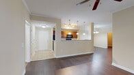 The Bromberg at 4306 N Shallowford Rd in Chamblee, Georgia, is a well-appointed 2-bedroom, 2-bathroom residence offering a thoughtfully designed single-floor layout. The open-concept living and dining area is anchored by rich, dark hardwood flooring and crown molding, with a ceiling fan overhead and large windows that invite an abundance of natural light and views of the surrounding greenery. A decorative chandelier highlights the dining area, which flows seamlessly into the kitchen. The kitchen features warm wood cabinetry, light countertops, black Whirlpool appliances including an electric range and over-the-range microwave, a pass-through breakfast bar with pendant lighting, and tile flooring. The entry foyer is finished in tile and provides a clean transition into the main living spaces. Both bedrooms are carpeted and offer generous proportions, with large windows for natural light. Each bedroom includes a walk-in closet with wire shelving systems for ample storage. The two bathrooms are finished with tile flooring, white vanity cabinetry, large mirrors, and glass-enclosed showers. The primary bathroom features an extended double vanity and a separate soaking tub, adding a touch of comfort and practicality to the space.