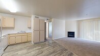Located at 30 Castlewood Drive in Pittsburg, California, this single-story, one-bedroom, one-bathroom residence offers a well-organized layout designed for comfortable living. The open-concept main area seamlessly connects the kitchen and living room, creating an efficient and functional flow. The kitchen is equipped with light wood cabinetry, white appliances including a refrigerator, electric range, microwave, and dishwasher, alongside a pantry-style storage unit. Hardwood-style vinyl flooring runs through the kitchen and entry areas, transitioning to plush wall-to-wall carpeting in the living room and bedroom. The living room is a standout feature, anchored by a sleek gas fireplace and a large sliding glass door with vertical blinds, allowing natural light to fill the space. The bedroom offers a comfortable footprint with carpeted flooring, a closet, and a window overlooking greenery. The full bathroom includes a tub/shower combination with a chrome curtain rod, a light wood vanity with a countertop sink, and hardwood-style flooring. Central HVAC with ceiling vents ensures year-round climate control. Neutral tones throughout lend a clean, move-in-ready feel to this practical and cozy residence.