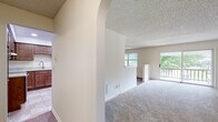 This single-floor apartment at 102 Shady Lane Apartments in Schenectady, NY offers a thoughtfully designed layout with a comfortable blend of function and style. The expansive living room is finished with plush carpeting, a textured ceiling, and a baseboard heating system. A sliding glass door leads to a private balcony overlooking lush greenery, filling the space with natural light. An elegant arched passageway connects the living area to the rest of the unit, adding a subtle architectural detail.

The kitchen is well-equipped and features rich, dark wood cabinetry, granite-style countertops, recessed lighting, and a full suite of stainless steel appliances including a range, dishwasher, and refrigerator. A pass-through window opens the kitchen to the adjacent dining area, which is accented by a classic chandelier and hardwood flooring, creating a warm and inviting atmosphere.

The bedroom is generously sized, carpeted, and includes a ceiling fan with light fixture. The bathrooms are finished with neutral tile flooring, wood-toned vanity cabinetry, and ample counter space, with one bathroom featuring a windowed wall for added brightness. Throughout the unit, neutral tones and clean lines create a calm, move-in-ready environment.