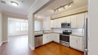 Located at 12000 Sweetwater Pl in Charleston, SC, this well-designed 2-bedroom, 2-bathroom residence offers a comfortable and functional single-floor layout. Warm hardwood flooring flows seamlessly throughout, complemented by neutral tones and crisp white trim and crown molding that lend a clean, classic aesthetic.

The open kitchen is a standout feature, boasting white shaker-style cabinetry, granite countertops, stainless steel appliances including a range, microwave, dishwasher, and refrigerator, and pendant and track lighting overhead. It opens directly to the living area, which is bright and airy with natural light filtering through windows and a ceiling fan overhead. A glass exterior door leads out from the living room.

The primary bedroom is generously sized, featuring crown molding, a ceiling fan, and a large walk-in closet outfitted with multi-level wire shelving and hanging rods. The second bedroom also offers hardwood floors and a ceiling fan. Both bathrooms are well-appointed, with one featuring a granite double-vanity, a combination tub and shower, and hardwood flooring. Additional conveniences include a dedicated laundry area and a hallway closet. This residence combines practical design with refined finishes throughout.