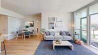 Located at 255 W 5th St in San Pedro, California, this thoughtfully designed single-floor residence combines contemporary architecture with coastal-inspired interiors. The open-concept living and dining area is anchored by light hardwood flooring and large floor-to-ceiling windows that invite abundant natural light. A gallery wall of nautical black-and-white photography adds character to the bright, airy living space, which flows seamlessly into the dining area.

The kitchen features a central island with bar seating, white quartz countertops, warm wood cabinetry, and stainless steel appliances, making it both functional and stylish. Adjacent shelving provides additional display and storage space.

The bedrooms are generously proportioned, finished with plush carpeting, and outfitted with closets for ample storage. The primary bedroom benefits from oversized windows offering panoramic harbor and cityscape views, while brass wall sconces and curated décor create a calm, sophisticated atmosphere. Additional bedrooms maintain the same clean, neutral palette and access to natural light.

The bathrooms feature light wood-tone vanities, white countertops, and wood-look flooring, offering a clean and modern finish. The layout flows intuitively throughout, making efficient use of the space while maintaining an open, comfortable feel well-suited for everyday living in the San Pedro waterfront community.