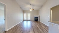 Located at 501 Tuscany Valley Ct in Crestview Hills, Kentucky, this two-bedroom, two-bathroom home offers a well-designed single-floor layout with a variety of attractive features. The open living room immediately impresses with its soaring vaulted ceilings, a ceiling fan, and a classic fireplace framed by a white mantel. French doors flood the space with natural light and provide outdoor access, while hardwood-style flooring runs seamlessly throughout the main living areas. The kitchen is equipped with granite countertops, white cabinetry, black appliances, and a breakfast bar that connects naturally to the living room, creating an open and functional flow. Pendant lighting adds a polished finishing touch overhead. Both bedrooms are carpeted and offer a comfortable, quiet retreat, with the primary bedroom providing a generous footprint and ample closet space. The bathrooms are finished with clean white cabinetry, tile flooring, and tub-shower combinations. A hallway connects the bedrooms and bathrooms, adding a sense of privacy from the main living spaces. The neutral color palette throughout creates a bright, cohesive ambiance that is both welcoming and easy to personalize.