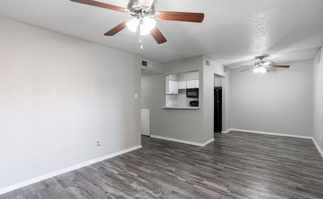 Bright and spacious living area paired with a stylish, functional kitchen. - Arbor Park Apartments