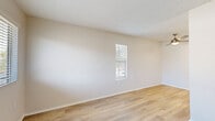 This single-floor unit in Livermore, California (94551) offers a clean, modern aesthetic defined by light wood-style flooring, crisp white walls, and textured ceilings throughout. The layout is thoughtfully arranged, with each room flowing naturally into the next via clean white doorways and open corridors.

The living and sleeping areas are bright and airy, featuring windows dressed with horizontal blinds that invite natural light while offering privacy. Views from the windows overlook the surrounding neighborhood. A wall-mounted HVAC unit in one of the rooms provides convenient climate control.

The kitchen is a standout feature, outfitted with white shaker-style cabinetry extending to the ceiling for ample storage, a stainless steel refrigerator, a gas range with overhead ventilation, and a stainless steel sink. Light countertops and the cohesive white palette give the kitchen a fresh, contemporary feel.

The bathroom is finished to a high standard, featuring a single-sink vanity with a white countertop and modern hardware, a large mirror, a combined tub and shower with safety grab bars, and matching light wood flooring that ties the space together seamlessly.

Overall, this unit presents a well-maintained, move-in-ready space with a neutral, versatile design suited to a variety of lifestyles.