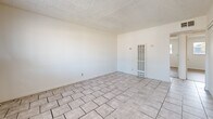 Located at 695 Plaza Ave in Sacramento, California, this 2-bedroom, 1-bathroom unit offers a practical and efficient single-floor layout. The living room is finished with light ceramic tile flooring and features a textured ceiling, bright white walls, and a window-mounted air conditioning unit that allows natural light to filter in. A wall heater adds functional climate control to the space.

Both bedrooms are appointed with warm hardwood-style plank flooring and textured ceilings. Each room includes a sliding-door closet for organized storage. The primary bedroom is comfortably sized and features a window with an outdoor view of surrounding greenery, while the second bedroom also benefits from natural light through its own window.

A connecting hallway with tile flooring links the main living areas to the bedrooms and bathroom. The bathroom is clean and straightforward, featuring white tile surround in the tub-shower combination, a single vanity with a mirror, and tile flooring.

The overall aesthetic is clean and neutral throughout, with white walls providing a bright and open feel. The consistent use of light tones across the flooring and walls creates a cohesive, move-in-ready environment suited for everyday living in the Sacramento area.