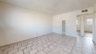 Located at 695 Plaza Ave in Sacramento, California, this 2-bedroom, 1-bathroom unit offers a practical and efficient single-floor layout. The living room is finished with light ceramic tile flooring and features a textured ceiling, bright white walls, and a window-mounted air conditioning unit that allows natural light to filter in. A wall heater adds functional climate control to the space.

Both bedrooms are appointed with warm hardwood-style plank flooring and textured ceilings. Each room includes a sliding-door closet for organized storage. The primary bedroom is comfortably sized and features a window with an outdoor view of surrounding greenery, while the second bedroom also benefits from natural light through its own window.

A connecting hallway with tile flooring links the main living areas to the bedrooms and bathroom. The bathroom is clean and straightforward, featuring white tile surround in the tub-shower combination, a single vanity with a mirror, and tile flooring.

The overall aesthetic is clean and neutral throughout, with white walls providing a bright and open feel. The consistent use of light tones across the flooring and walls creates a cohesive, move-in-ready environment suited for everyday living in the Sacramento area.