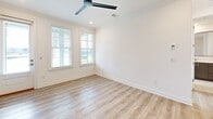 Located at 77 Exuma Way in Santa Rosa Beach, Florida, this thoughtfully designed one-bedroom, one-bathroom residence offers a clean, contemporary aesthetic across a single floor. Light wood-look plank flooring runs throughout, complementing the crisp white walls and crown molding that frame each room. The open-concept kitchen and living area serves as the heart of the home, anchored by a large peninsula with quartz countertops and an undermount sink. Dark espresso cabinetry provides a striking contrast to the white subway tile backsplash and light surfaces, while stainless steel appliances — including a refrigerator with ice maker, electric range, and built-in microwave — deliver a polished, functional workspace. Pendant lighting with glass shades adds a refined touch above the kitchen peninsula. The living area features multiple windows and a front entry door that floods the space with natural light, enhanced by a modern ceiling fan. The bedroom is generously proportioned with a ceiling fan, window with blinds, and direct access to a walk-in closet outfitted with multi-tier wire shelving for ample storage. The bathroom offers a dark wood vanity with a quartz countertop and an oversized glass-enclosed walk-in shower with full tile surround. An in-unit laundry area completes this well-appointed home.