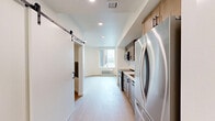 Located on the sixth floor at 440 W Columbia Way in Vancouver, WA, this one-bedroom, one-bathroom unit offers a thoughtfully designed single-level layout with modern finishes throughout. Light-toned hardwood-style flooring flows seamlessly across every room, creating a cohesive and clean aesthetic.

The open kitchen is a standout feature, showcasing warm natural wood cabinetry with matte black hardware, a white tile backsplash, light stone countertops, and a full suite of stainless steel appliances including a gas range, microwave, and dishwasher. The kitchen opens directly to the living area, fostering an airy, connected feel.

The bedroom offers a comfortable, private retreat with a sliding door and access to a closet with built-in storage. Crisp white walls and recessed lighting keep the space bright and versatile.

The bathroom is well-appointed with a warm wood vanity, undermount sink, matte black fixtures, a large rectangular mirror, and a spacious walk-in glass-enclosed shower with tile surround. A stacked in-unit washer and dryer adds everyday convenience.

The entrance provides a welcoming transition into the home. Throughout, the unit maintains a clean, contemporary aesthetic with neutral tones and quality materials that balance style and functionality.