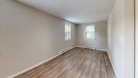 Located at Harbor Village Drive in Middletown, Rhode Island, this single-floor, one-bedroom, one-bathroom unit offers a practical and comfortable layout with thoughtful finishes throughout. The living room greets you with warm hardwood-style flooring, a ceiling fan with integrated lighting, dual windows that invite generous natural light, and a wall-mounted AC unit for year-round comfort. Baseboard heating runs throughout the unit, ensuring consistent warmth. The kitchen is well-equipped with rich wood cabinetry, granite-look countertops, a stainless sink, and a full suite of appliances including a white electric range, refrigerator, and black dishwasher. A window above the sink provides added brightness to the space. The bedroom features plush carpeting, baseboard heating, a natural light-filled window, and a sliding-door closet with a full-width hanging rod for ample storage. The full bathroom is finished with large-format marble-style tile surrounding the tub and shower, a wood-toned vanity with a light countertop, hardwood-style flooring, and a window for natural ventilation. Neutral tones and clean lines create a cohesive, move-in-ready ambiance throughout the entire unit.