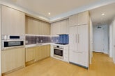 Located in the heart of Washington, DC, this thoughtfully designed two-bedroom, two-bathroom residence at 1224 M St NW offers a clean, modern aesthetic throughout. Light wood flooring flows seamlessly across the single-level floor plan, complementing the bright white walls and recessed lighting that keep the space feeling open and airy.

The kitchen is a standout feature, outfitted with flat-front light wood cabinetry, stainless steel Bosch appliances including a gas range, wall oven, and built-in microwave, and a sleek tile backsplash in cool blue-grey tones. The adjacent combined dining and living area provides a versatile, open space with room to entertain.

Both bedrooms are well-proportioned and bathed in natural light. The primary bedroom features floor-to-ceiling sliding glass doors that open to outdoor views of surrounding greenery and the cityscape, while the second bedroom includes a large window framing similar views. Each room benefits from recessed lighting and ample closet space, with three closets distributed throughout the unit.

The two bathrooms are finished with marble-look tile flooring, wood-toned floating vanities with white countertops, and textured tile surrounds in the shower and tub areas. Connecting hallways are clean and well-lit, completing this polished, contemporary residence.