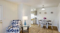 Located in Orange Park, FL, this two-story, two-bedroom, two-bathroom home offers a well-organized layout spread across two levels. The main living area on the upper floor is bright and open, with large windows allowing generous natural light and ceiling fans providing comfort throughout. The kitchen is a standout feature, showcasing rich dark wood cabinetry, granite-style countertops, hardwood-style flooring, stainless steel appliances, and a peninsula with pendant lighting that connects seamlessly to the open living area. The bathrooms are finished with tile flooring, granite-topped vanities, and full tub-shower combinations. Both bedrooms are carpeted and well-sized, with the primary bedroom offering a spacious walk-in closet equipped with built-in wire shelving on multiple walls, providing ample storage. The second bedroom is equally comfortable with its own closet access. A dedicated laundry room adds everyday convenience. Carpeted staircases with white handrails connect the entry-level foyer to the main living floor above. Multiple hallways provide smooth circulation throughout the home. The clean, neutral color palette and consistent finishes give the space a cohesive and move-in ready feel.