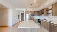 Located at 355 Biscayne Blvd Way in the heart of Miami, FL, this modern 2-bedroom, 2-bathroom residence offers a sleek, contemporary design throughout. The open-concept living and dining area features large-format light tile flooring and a ceiling fan, creating a bright and airy atmosphere. Floor-to-ceiling sliding glass doors flood the space with natural light and frame striking views of the Miami skyline.

The kitchen is a standout feature, showcasing warm wood-tone cabinetry, a white subway tile backsplash, stainless steel appliances including a French door refrigerator, built-in microwave, range, and dishwasher, all anchored by a generous island with a crisp white quartz countertop and stylish pendant lighting.

Both bedrooms continue the light tile flooring and feature large sliding glass doors with balcony access and panoramic city views, complemented by roller shades for privacy. Each bedroom is served by its own dedicated closet space.

The two bathrooms are finished in clean white large-format tile, each equipped with a soaking tub and shower combination, chrome fixtures, and wood-toned vanity cabinetry. Three hallways connect the space efficiently, and a smart thermostat adds a modern convenience touch throughout this well-appointed urban residence.