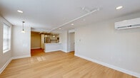 This 2-bedroom, 1-bathroom residence at 200 Broadway in Troy, NY offers a thoughtfully designed single-floor layout with a clean, contemporary aesthetic. The open-concept living and dining area is anchored by light hardwood flooring, recessed lighting, and a wall-mounted mini-split system, with multiple windows fitted with blinds that invite ample natural light. The kitchen seamlessly connects to the living space and features white shaker-style cabinetry, a light quartz countertop, stainless steel appliances including a range, microwave, dishwasher, and refrigerator, plus pendant lighting above a peninsula breakfast bar. Both bedrooms are carpeted in warm neutral tones and include closets, track lighting, and windows that bring in natural light. The primary bedroom benefits from a wall-mounted mini-split unit for climate control. The shared full bathroom is well-appointed with large-format tile flooring, a spacious white vanity with dual sinks, a wide mirror with globe lighting, and accessibility grab bars. A connecting hallway ties the layout together, providing smooth circulation throughout. The overall palette of soft whites and warm beiges creates a bright, cohesive ambiance across the entire residence.