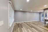 Located at 2220 E 7th St in Charlotte's vibrant Plaza Midwood neighborhood, this thoughtfully designed one-bedroom, one-bathroom unit offers a modern and cohesive living experience on a single floor. Light gray walls and wood-look luxury vinyl plank flooring flow consistently throughout, creating a clean and contemporary aesthetic.

The open-concept kitchen and living area serves as the heart of the home. The kitchen is outfitted with white shaker-style cabinetry, white quartz countertops, a peninsula with a single-basin undermount sink, and a full suite of stainless steel appliances including a refrigerator, range, and microwave. The living area features recessed lighting, large windows with slatted blinds for natural light control, and a white brick fireplace as a standout focal point.

The bedroom is a comfortable retreat with a ceiling fan, a sliding glass door opening to a private patio, and direct access to the in-unit stacked washer and dryer. Two closets provide ample storage. The bathroom is elegantly finished with marble-style tile on both the floor and tub surround, paired with a white vanity and chrome fixtures. A second patio adds additional outdoor space, completing this well-appointed unit.
