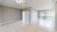 Located at 305 Glades Cir in Largo, Florida, this single-floor, two-bedroom, one-bathroom home offers a practical and functional layout across a compact, efficiently designed footprint. The interior features light beige tile flooring throughout, neutral gray walls, and white baseboards that lend a clean, cohesive look to every room.

The living and dining areas are open and airy, benefiting from large windows and sliding glass door access to an outdoor space, dressed with vertical blinds. A ceiling fan adds comfort to the living area, which also features a textured ceiling.

The galley-style kitchen is well-appointed with white upper and lower cabinetry, a stainless steel sink, a dishwasher, a range, and a full-size refrigerator, all set over the same tile flooring that runs throughout the home.

Both bedrooms are generously sized relative to the overall floor plan, each featuring expansive louvered bi-fold closet doors providing ample storage. The primary bedroom includes multiple closet panels spanning nearly an entire wall. Natural light fills the bedrooms through windows with blinds.

The bathroom is clean and straightforward, featuring a white tiled tub-shower combination. This home offers a bright, low-maintenance living environment well-suited to the Florida lifestyle.