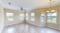 Located at 10558 Eastern Shore Blvd, this well-appointed 3-bedroom, 2-bathroom home offers a functional and comfortable layout across a single floor. The open-concept kitchen and living room serve as the heart of the home, featuring light hardwood-style flooring, crown molding, and abundant natural light streaming through multiple windows dressed with blinds. A ceiling fan with a light fixture enhances comfort, while a chandelier adds a touch of elegance near the dining area. The kitchen is equipped with warm wood cabinetry, granite countertops, a subway tile backsplash, tile flooring, and a built-in dishwasher, opening seamlessly to the living space. The primary bedroom offers a generous footprint with plush carpet, dual windows with outdoor views, and access to a walk-in closet fitted with wire shelving. Additional bedrooms are carpeted and bright, each with window access to natural light. The bathrooms feature tile flooring, granite vanity countertops, wood cabinetry, and a tub-shower combination. A dedicated laundry room accommodates a full-size washer and dryer with overhead shelving. Carpeted staircases with white railings connect levels, and multiple hallways and closets throughout ensure ample storage. The home's warm neutral palette and thoughtful layout create a welcoming, move-in-ready atmosphere.