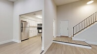 This two-story, three-bedroom, two-bathroom home in Lawrenceville, GA offers a well-organized layout across two floors, with the majority of the living space situated on the main level. Throughout the home, light wood-style flooring creates a clean, cohesive look that enhances the bright, neutral color palette.

The main level features two living areas, one of which showcases sliding glass doors that open to outdoor greenery, filling the space with natural light and providing pleasant exterior views. Recessed lighting and large windows with blinds further illuminate the open, airy rooms. The kitchen is outfitted with white shaker-style cabinetry, subway tile backsplash, stainless steel appliances including a range, microwave, and dishwasher, and a window above the sink.

The bedrooms are generously proportioned, each featuring ceiling fans with integrated lighting and windows that invite natural light. The spacious primary bedroom offers ample room for a full furniture arrangement. Both bathrooms are cleanly finished with wood-style flooring, white fixtures, and neutral tones.

A staircase connects the main level to the upper floor, which houses additional bedroom space. The hallway provides efficient circulation throughout. Overall, the home presents a fresh, move-in-ready feel with consistent finishes and a functional, comfortable layout.