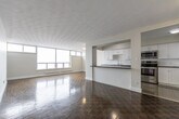 Located at 277 Anderson Ave in Oshawa, Ontario, this well-appointed 2-bedroom, 1-bathroom unit offers a generous and thoughtfully laid-out floor plan. The open-concept living, dining, and kitchen area forms the heart of the home, bathed in natural light from expansive floor-to-ceiling windows that frame outdoor views of the surrounding neighbourhood. Parquet hardwood flooring extends throughout the living spaces, adding warmth and character to the bright, neutral interior.

The kitchen is equipped with stainless steel appliances — including a range, over-the-range microwave, dishwasher, and refrigerator — complemented by crisp white shaker cabinetry, white subway tile backsplash, and dark countertops. A peninsula with a dark countertop provides additional workspace and separates the kitchen from the living area. Light tile flooring grounds the kitchen zone distinctly from the rest of the unit.

Both bedrooms feature parquet flooring and ample natural light, with the primary bedroom offering a mirrored sliding-door closet. The bathroom is finished with classic white subway tile surrounding a full soaker tub and shower. A private balcony extends the living space outdoors, completing this comfortable and functional Oshawa residence.