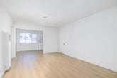 Located along the iconic Sunset Boulevard in the desirable Brentwood neighborhood of Los Angeles, this one-bedroom, one-bathroom residence offers a clean, functional layout with a bright and airy atmosphere throughout. Warm-toned hardwood floors run continuously through the living room, hallway, and bedroom, lending a cohesive and inviting feel to the space.

The open living area is generously proportioned, bathed in natural light streaming through large windows dressed with vertical blinds that offer both privacy and a soft, diffused glow. The galley-style kitchen is efficiently designed, featuring white cabinetry that extends to the ceiling for ample storage, white appliances including a gas range and refrigerator, and a window that brings in additional natural light.

The bedroom is a comfortable retreat, complete with built-in sliding-door closets with overhead storage, a window, and the same rich hardwood flooring found throughout. A connecting hallway provides a smooth transition between the living spaces and the bathroom.

The bathroom is finished in a clean, all-white palette, featuring a tiled shower-tub combination with glass sliding doors, a vanity with cabinet storage, and tile flooring. The overall design is simple and understated, offering a neutral canvas well-suited to a variety of personal styles.