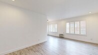 Located at 1776 N Sycamore Ave in the heart of Hollywood, Los Angeles, this 2-bedroom, 1-bathroom unit offers a clean, modern aesthetic throughout its efficiently designed single-floor layout. Light wood-style flooring runs consistently across every room, lending a cohesive and airy feel to the entire space.

The open living and kitchen area is bright and welcoming, with plantation shutters allowing natural light to filter in while maintaining privacy. A wall-unit air conditioner provides climate control, and a circular pendant light adds a contemporary touch. The galley-style kitchen is well-appointed with white shaker cabinetry, glass-front upper cabinets, grey quartz countertops, a subway tile backsplash, and stainless steel appliances including a gas range, dishwasher, and refrigerator.

Both bedrooms feature ceiling fans, crisp white walls, and recessed lighting. The primary bedroom includes a mirrored sliding-door closet and connects to the hallway, while the secondary bedroom offers a large window with views of the surrounding neighborhood. The bathroom stands out with elegant marble-style wall tile surrounding a soaking tub and shower combo, accented by gold-tone hardware and frameless glass sliding doors. A hallway connects all rooms, completing this well-organized and stylishly updated Hollywood residence.