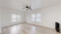 Located at 511 S Serrano Ave in the heart of Los Angeles, this thoughtfully designed single-floor unit offers a clean, modern aesthetic throughout. The living area is bright and airy, featuring light wood-style flooring, crisp white walls, and multiple windows fitted with horizontal blinds that invite natural light. A ceiling fan with an integrated light fixture adds both comfort and style, while a classic cast-iron radiator provides a charming functional accent. The space flows efficiently through a dedicated entrance into the main living areas, supported by two closets — one of which features sleek black-framed mirrored sliding doors, adding depth and a contemporary touch. The galley-style kitchen is a standout, showcasing bold black marble-veined countertops that contrast beautifully against white shaker cabinetry with matte black hardware. Stainless steel appliances, including a refrigerator and range, complement the polished white tile flooring and a window that keeps the space bright. The bathroom maintains the unit's clean, white palette with marble-look tile flooring, a combined tub and shower, a pedestal sink, and a frosted window for natural light and privacy. Throughout, the consistent use of white tones, modern fixtures, and light flooring creates a cohesive and inviting atmosphere.