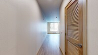 This 310-square-foot studio apartment at 4544 7th Ave NE in Seattle's vibrant 98105 neighborhood offers an efficient, modern single-floor layout. The open living area features light-toned hardwood-style flooring and neutral walls, creating a clean, airy atmosphere. A large window allows natural light to fill the space while offering views of the surrounding neighborhood.

The kitchen is well-appointed with warm wood-toned cabinetry, open shelving, and a full suite of stainless steel appliances including a refrigerator, electric range with oven, over-the-range microwave, and dishwasher. A single-basin sink with ample counter space completes the functional cooking area. Recessed lighting adds a modern touch overhead.

The bathroom is finished with coordinating wood-toned vanity cabinetry, a stone-patterned countertop with an integrated sink, a wall-mounted mirror, and light hardwood-style tile flooring. A sliding glass-door shower/tub enclosure and taupe-toned walls contribute to the room's clean, contemporary aesthetic.

A closet area with louvered doors provides practical storage within the unit's compact footprint. Baseboard heating is present throughout. This studio is ideally situated for those seeking a functional, modern living space in Seattle's University District.
