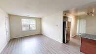 Located at 5325 Justin Ct in Virginia Beach, VA, this two-bedroom, one-bathroom unit offers a practical and well-appointed single-floor layout. The open-concept living and kitchen area provides a welcoming, airy feel, with light hardwood-style flooring extending throughout the main living spaces. Natural light filters in through windows fitted with blinds, brightening the neutral-toned walls and creating a clean, comfortable atmosphere.

The kitchen is a functional highlight, featuring rich cherry wood cabinetry, granite countertops, a tile backsplash, a double-basin sink, and stainless steel appliances including a full-size refrigerator. Track lighting overhead ensures the kitchen is well-lit, and a peninsula counter provides additional workspace and a natural division from the living area.

Both bedrooms are carpeted and receive natural light through windows. The primary bedroom is a comfortable size and includes access to a dedicated closet with built-in shelving. A second closet provides additional storage elsewhere in the unit. The bathroom is straightforward and clean, equipped with a full soaking tub and shower combination. The overall design is simple and move-in ready, making this Virginia Beach unit a practical choice for everyday living.