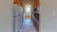 Located at 820 Carvel Dr in Dover, Delaware, this single-floor residence offers a practical and well-organized layout. The galley-style kitchen is efficiently designed with warm wood cabinetry lining both sides, dark granite countertops, a double-basin sink, and wood-look vinyl flooring. A window at the end of the kitchen allows natural light to filter in, and appliances including a refrigerator and range are included.

The living area is generously proportioned, featuring neutral wall-to-wall carpeting and multiple windows that bring in natural light and views of the surrounding neighborhood. The open feel of this space provides flexibility for a variety of furniture arrangements.

The bedrooms continue the carpeted aesthetic and maintain a clean, neutral palette. Each room includes closet storage with louvered or paneled sliding doors, and one bedroom features direct access to the bathroom. The full bathroom is outfitted with a tub-shower combination unit, tile-accented walls with a subtle teal detail, wood-look vinyl flooring, and standard fixtures throughout.

Overall, the space presents a clean, move-in-ready environment with consistent finishes, ample storage, and a straightforward single-level floor plan suited for comfortable everyday living.