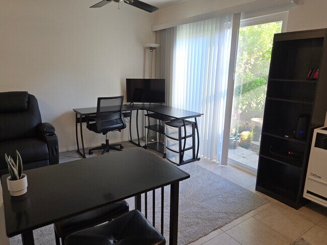 View from kitchen into living room area. Workstation, massaging reclyner, wall shelving unit - 7649 Beckett St