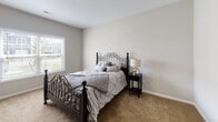 Located at 4214 California Rd in Orchard Park, NY, this well-appointed single-floor residence offers a thoughtfully designed open-concept layout with a clean, modern aesthetic throughout. Light wood-style flooring flows seamlessly across the main living areas, complementing the neutral warm tones of the walls and trim.

The kitchen is a standout feature, outfitted with white shaker-style cabinetry, granite countertops, a subway tile backsplash, and a full suite of stainless steel appliances including a gas range, over-the-range microwave, and French door refrigerator. A kitchen island provides additional prep and seating space.

The living area is open and welcoming, with a sliding glass door that invites natural light and provides access to the outdoors. A dedicated dining area accommodates casual meals with ease.

The bedrooms offer a comfortable retreat, each featuring plush carpeting, neutral walls, and windows that bring in natural light with outdoor views. The bathrooms are finished with granite-topped vanities and wood-style flooring. One bathroom features a walk-in glass-enclosed shower with classic white subway tile surround and grab bars for added accessibility.

The entryway is clean and functional, with multiple interior doors providing organized access to additional storage or utility spaces. This residence combines practical design with quality finishes throughout.