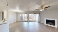 This single-story, 2-bedroom, 2-bathroom home in Fort Worth, Texas offers a well-organized layout with comfortable living spaces throughout. The combined living and dining area is a standout feature, highlighted by light wood-style flooring, a textured ceiling, a ceiling fan, and a classic fireplace. Large sliding glass doors span the rear wall, flooding the space with natural light and providing direct access to a private patio with a fenced enclosure — ideal for outdoor relaxation. The kitchen features white cabinetry, light countertops, and stainless steel appliances including a refrigerator and dishwasher, complemented by a window above the sink that brings in additional natural light. The generously sized primary bedroom offers ample space and includes a walk-in closet with built-in shelving and hanging rods for organized storage. The second bedroom is equally well-proportioned with its own closet access. Both bathrooms are finished with wood-style flooring, with one featuring a walk-in shower with sliding glass doors and a vanity with a light stone-style countertop. A hallway connects the living areas to the bedrooms, and three total closets provide plentiful storage. The home's neutral color palette and clean finishes create a bright, move-in-ready atmosphere throughout.